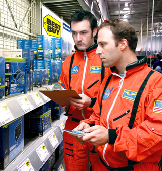 Commanders Scott Dreisen and Alan Wittmer explore a Houston-area Best Buy for possible signs of wireless routers in NASA's heroic first steps into the Wi-Fi Age.